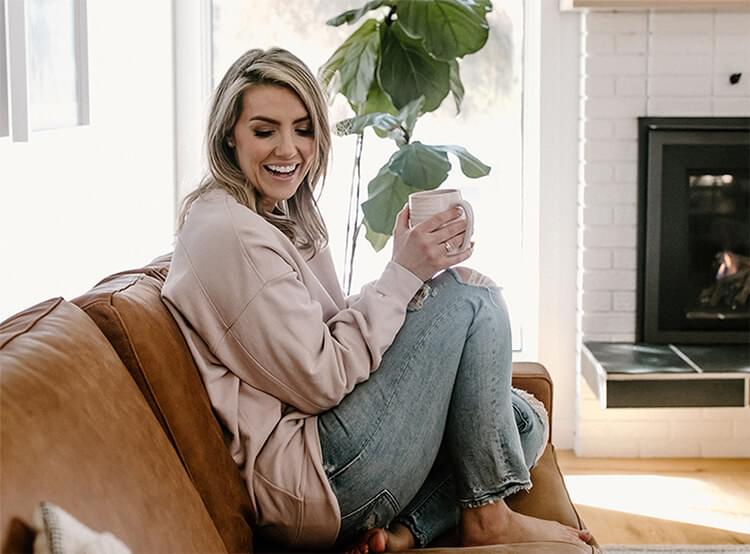 Woman sitting on her sofa holding a mug